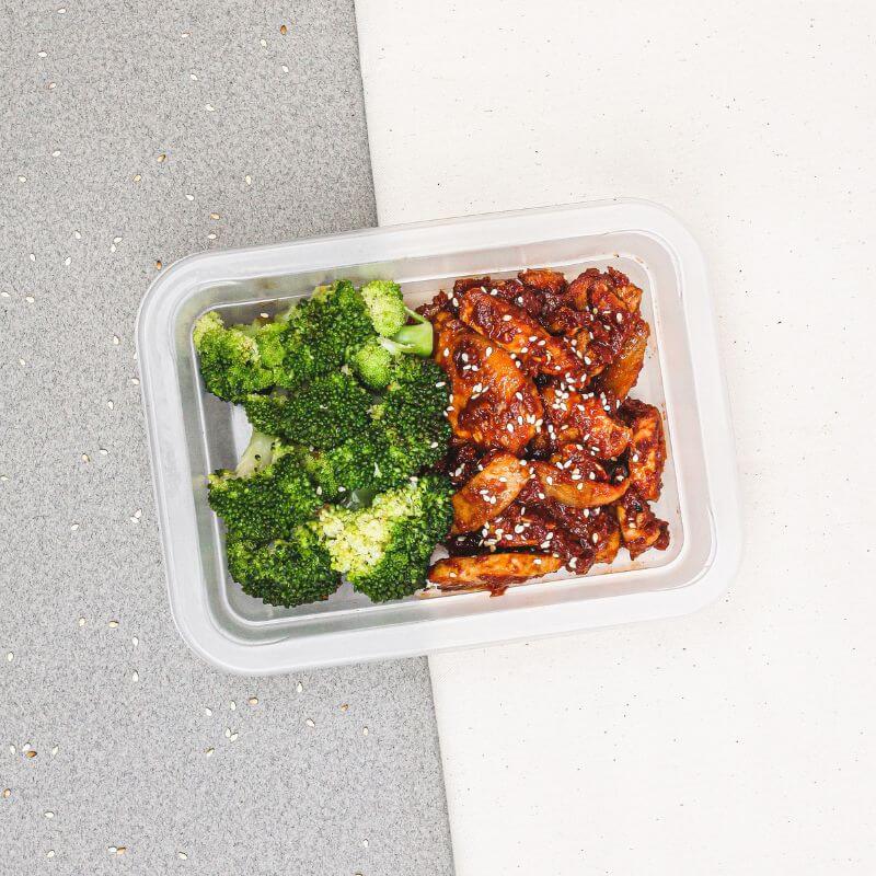 Korean Sesame Chicken and Broccoli in a neatly packed meal container, highlighting the tender chicken breast, sticky sesame sauce, and vibrant broccoli.