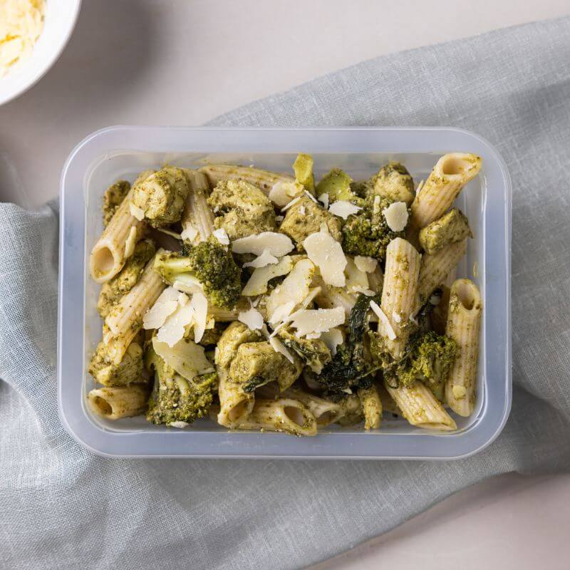 Chicken Pesto Penne served in a meal container, showcasing the gluten-free penne, chicken breast, and vibrant pesto sauce in an appetizing, neatly packaged presentation.