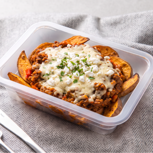 Top-down view of loaded sweet potato wedges in our Nourish'd container, topped with beef chilli and melted tasty cheese
